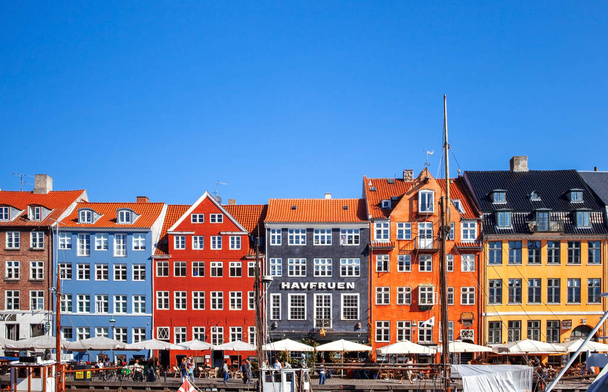 COPENHAGEN, DENMARK - SEPTEMBER 9: people in open cafes of the famous Nyhavn promenade on September 9, 2016 in Copenhagen, Denmark. Nyhavn is one of the most famous landmark of Copenhagen. - Foto, Bild