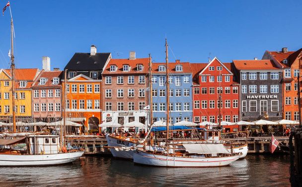 COPENHAGEN, DENMARK - SEPTEMBER 9: people in open cafes of the famous Nyhavn promenade on September 9, 2016 in Copenhagen, Denmark. Nyhavn is one of the most famous landmark of Copenhagen. - 写真・画像