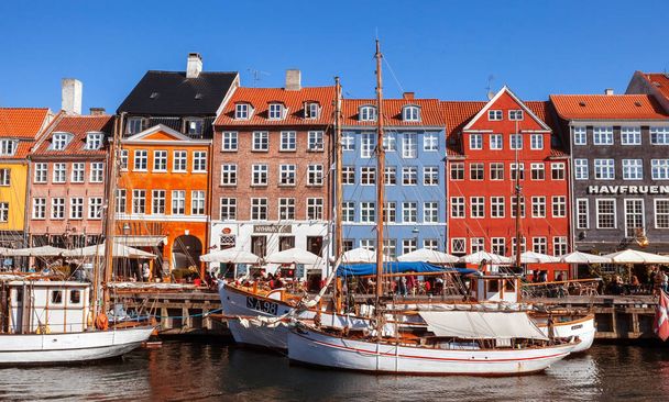 COPENHAGEN, DENMARK - SEPTEMBER 9: people in open cafes of the famous Nyhavn promenade on September 9, 2016 in Copenhagen, Denmark. Nyhavn is one of the most famous landmark of Copenhagen. - Foto, Bild
