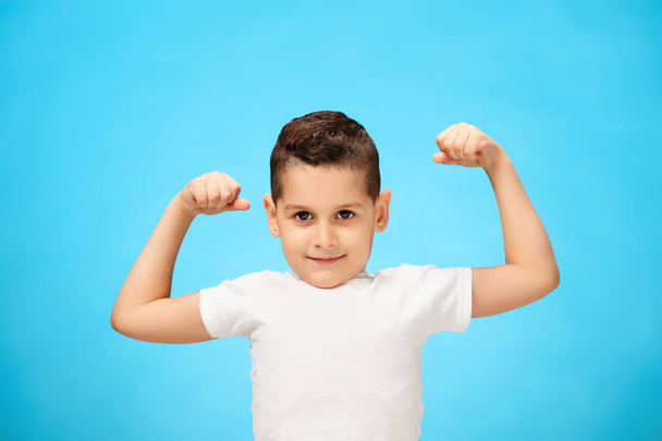Beauty smiling sport child boy showing his biceps - Foto, afbeelding