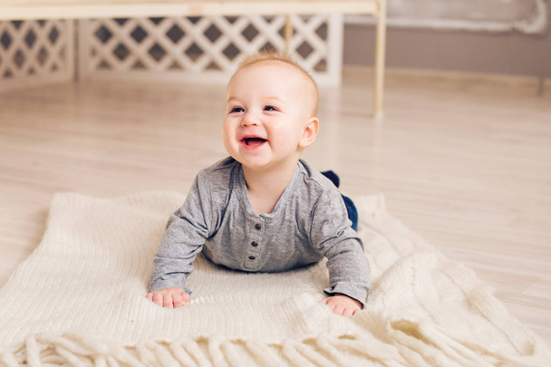 Adorable laughing baby boy in white sunny bedroom. Newborn child relaxing. Family morning at home. - Fotografie, Obrázek