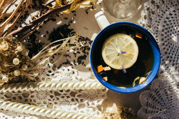 Black tea with blue flowers, orange peel and petals in blue and  - Foto, imagen