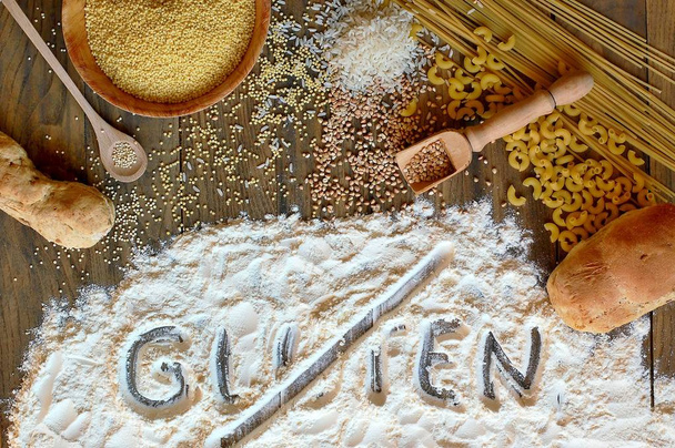 Céréales sans gluten maïs, riz, sarrasin, quinoa, millet, pâtes et farine avec texte rayé gluten sur fond de bois brun
 - Photo, image