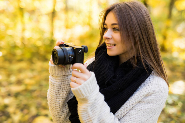 Girl take photo with camera in yellow autumn park - Photo, image