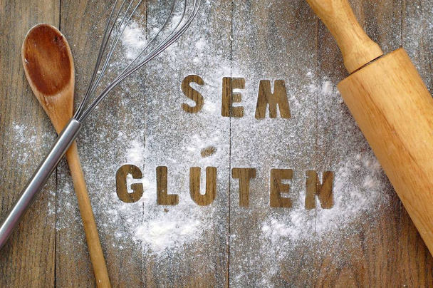 Gluteeniton jauhot tekstillä gluteeniton portugalin kielellä puulusikka, vispilä ja valssaustappi tummanruskea puinen tausta
 - Valokuva, kuva
