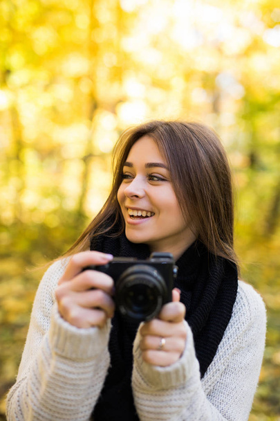 Κορίτσι τραβάτε selfie φωτογραφία με την κάμερα στο κίτρινο Φθινοπωρινό πάρκο - Φωτογραφία, εικόνα