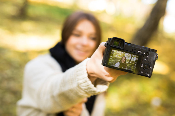 Menina tirar foto selfie com câmera no parque de outono amarelo
 - Foto, Imagem