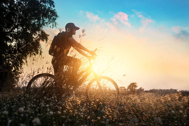 Motoros mountain bike kaland jellegű gyönyörű virágok, nyári naplementében - Fotó, kép