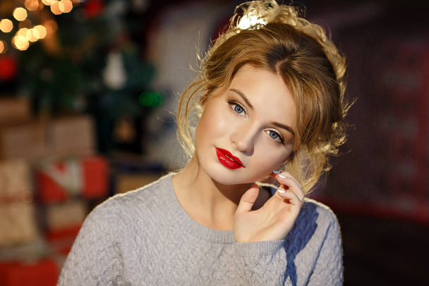 Portrait of surprised blonde glamor girl with gifts in hands on  - 写真・画像