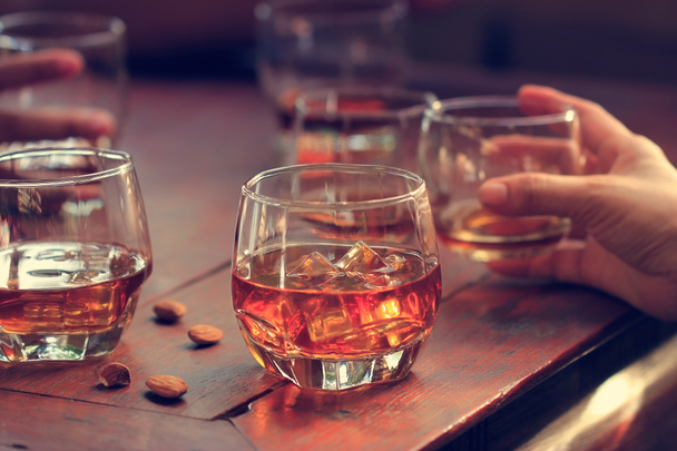 Whisky bourbon en vasos con hielo sobre fondo de mesa de madera
 - Foto, imagen