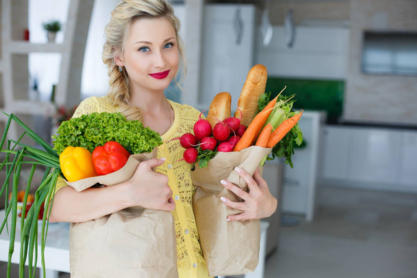 Felice giovane casalinga con borse piene di verdure
 - Foto, immagini