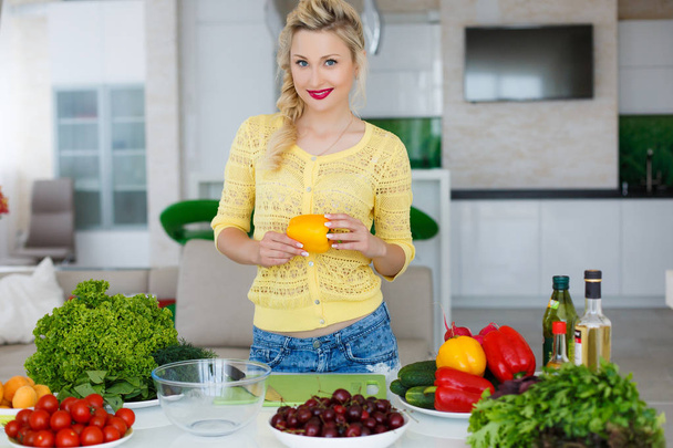 Young housewife preparing salad in the kitchen - Photo, Image