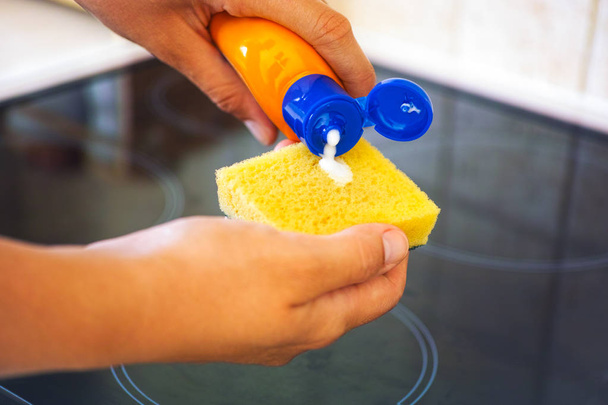 Woman hands with yellow sponge and bottle of cleaning detergent - Photo, Image