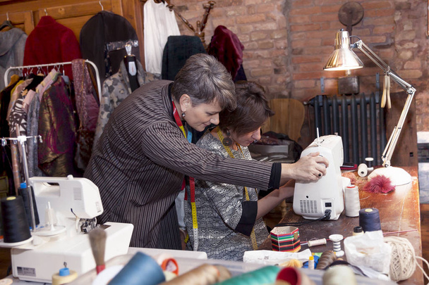 dressmaker couple is working with the sewing machine - Photo, Image