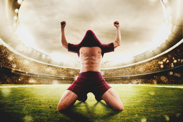 Футболист ликует на стадионе
 - Фото, изображение