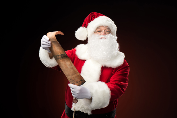 Santa Claus de pie con la lista de deseos
 - Foto, imagen