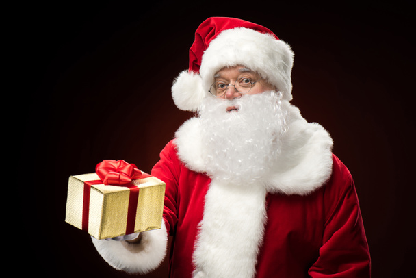 Santa Claus with gift box in hand - Фото, зображення