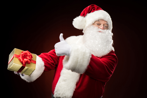 Santa Claus with gift box in hand - Фото, зображення
