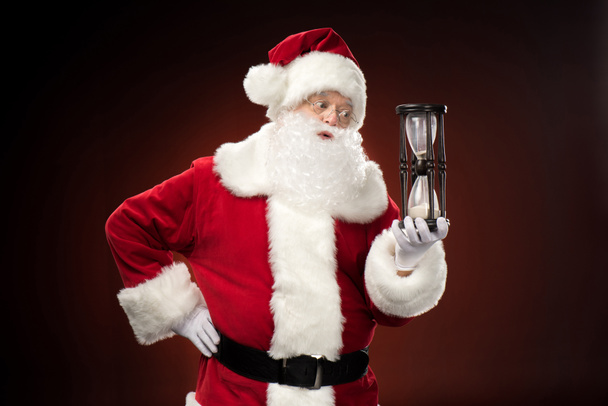 Santa Claus holding hourglass   - Fotografie, Obrázek