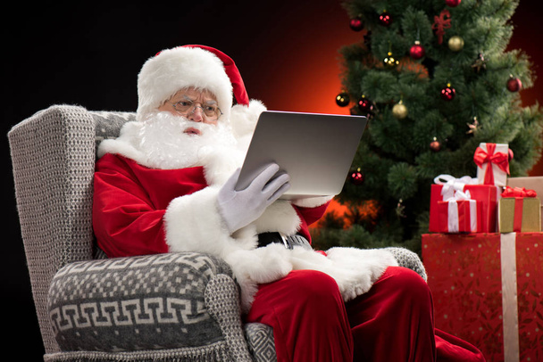 Santa Claus using laptop - Фото, зображення