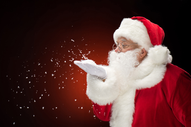 Санта-Клаус выдувает снежинки
   - Фото, изображение