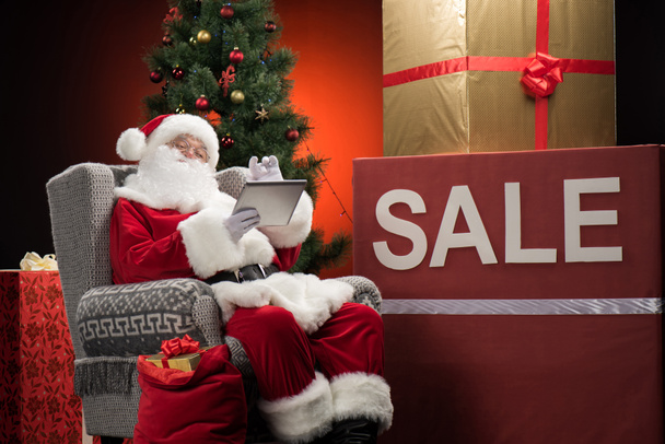Санта-Клаус с вывеской Sale
 - Фото, изображение
