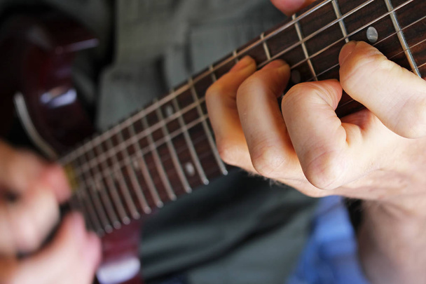 エレク トリック ギターの弦をかき鳴らすミュージシャン - 写真・画像