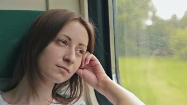 mladá žena při pohledu z okna vlaku - Záběry, video