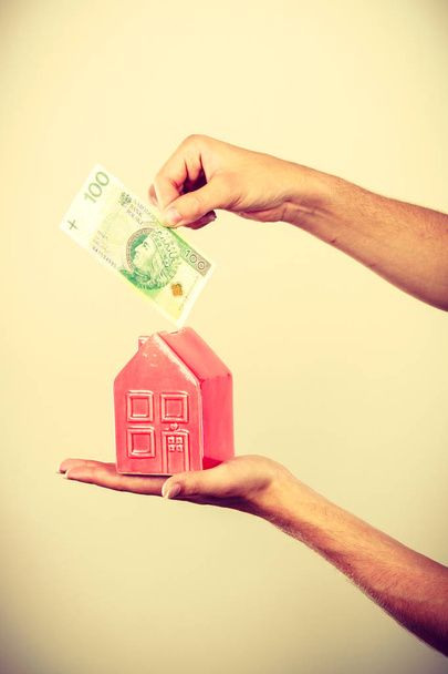 Ο άνθρωπος που βάζει χρήματα στον κουμπαρά του σπιτιού - Φωτογραφία, εικόνα