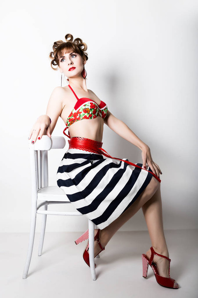 young beautiful woman sitting on a chair, pin-up style, girl styling hair with curlers - Fotoğraf, Görsel