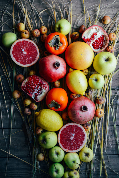 Různé čerstvé citrusové plody v koši na dřevěné pozadí - Fotografie, Obrázek