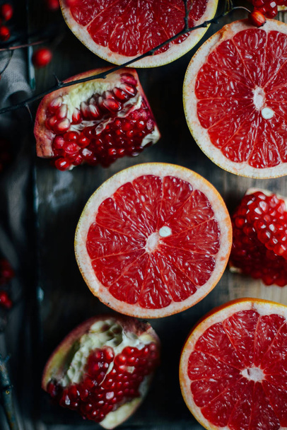 frischer roter Granatapfel und Grapefruit auf einem hölzernen Hintergrund. pom - Foto, Bild