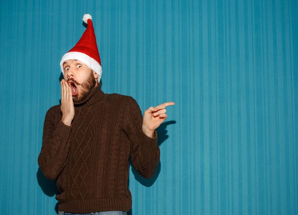 Surprised christmas man wearing a santa hat - Photo, image