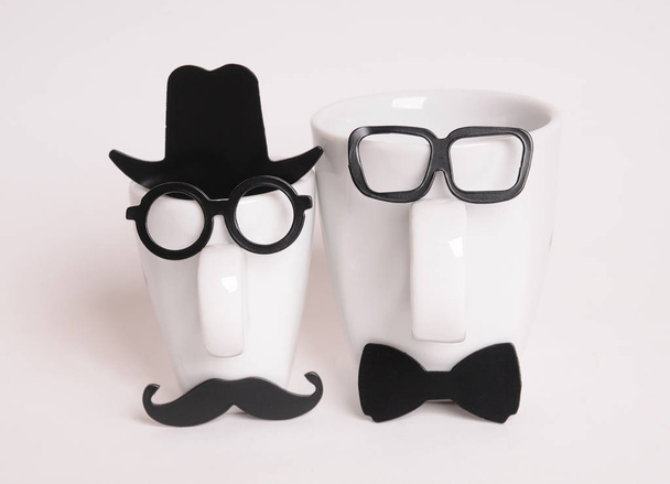 Two coffee cups in mans image. Hipster style, glasses, mustache, hat, bow tie - Photo, Image