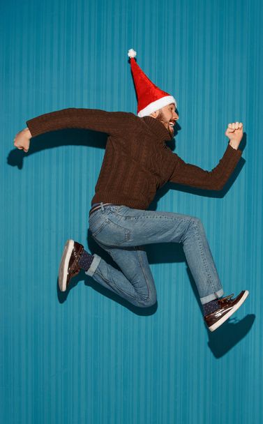 The running christmas man wearing a santa hat - Foto, afbeelding