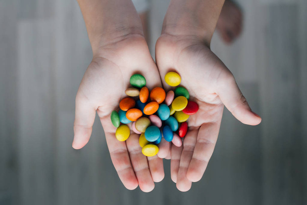A child holding a handful of candy - Foto, Imagen