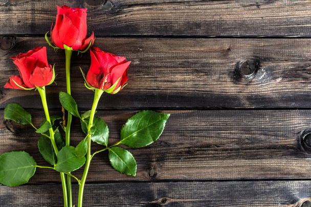 Red roses on wood, valentines card with copy space, overhead - Photo, Image