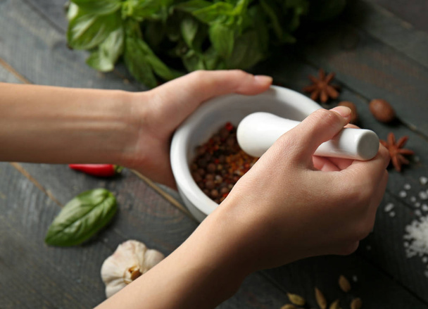 hands grinding spices in mortar - Фото, изображение