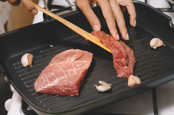 Şef lezzetli sığır eti biftek et sarımsak Pan ile hazırlanıyor - Fotoğraf, Görsel