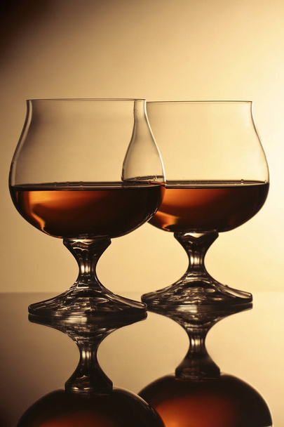 due bicchieri con cognac su sfondo marrone
 - Foto, immagini