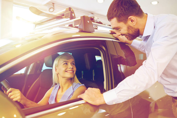 happy couple buying car in auto show or salon - Foto, imagen
