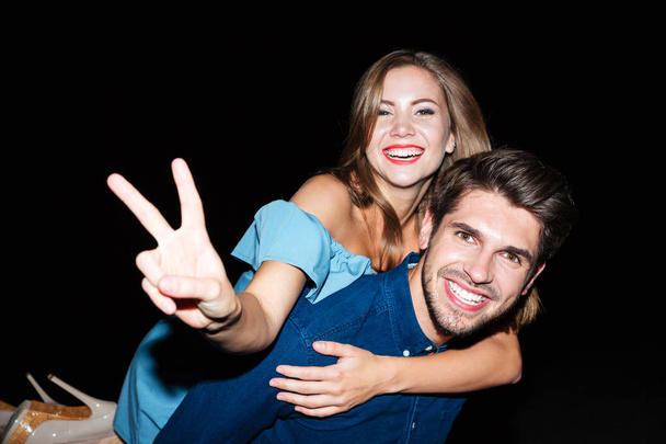 Cheerful young couple showing peace sign and having fun - Fotografie, Obrázek