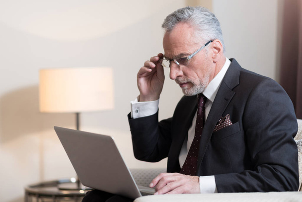 Concentrated businessman working with the laptop in the hotel - Photo, Image
