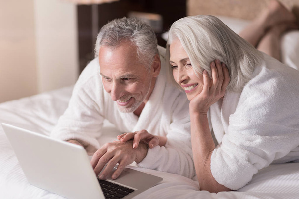 Pleasant aged couple surfing the Internet at home - Φωτογραφία, εικόνα