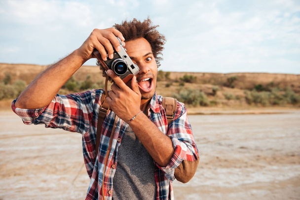 Cheerful man taking pictures and having fun on the beach - Фото, изображение