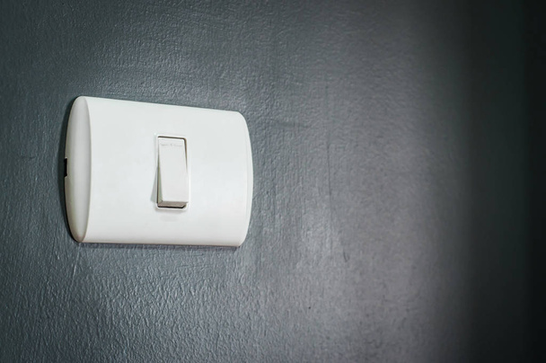 lighting switch on dark blue wall. - Фото, зображення