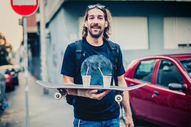 Skateboarder make fun and brings coffee on skateboard - Fotó, kép