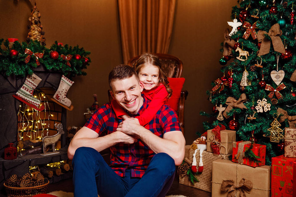 Child with dad near Christmas tree - Foto, afbeelding