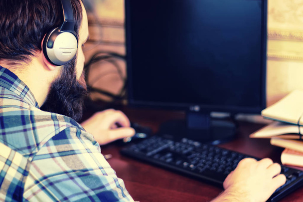 male behind computer with headphones - Foto, afbeelding
