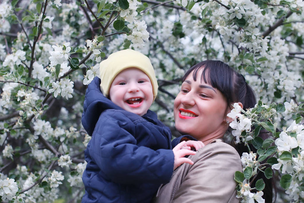 Äiti vauvan kanssa omenapuutarhassa
 - Valokuva, kuva